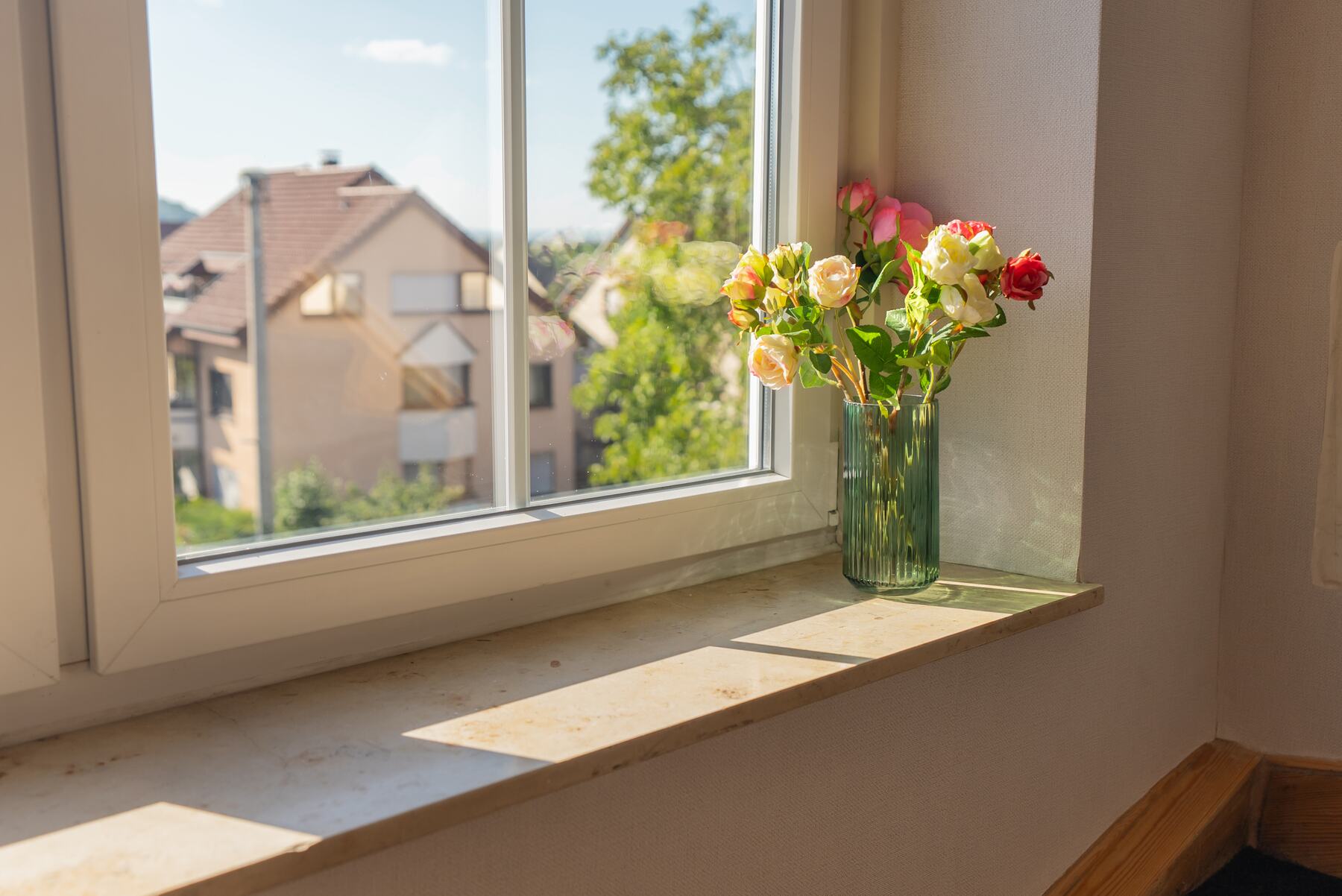 Fensterbank mit Blumenstrauß und Ausblick